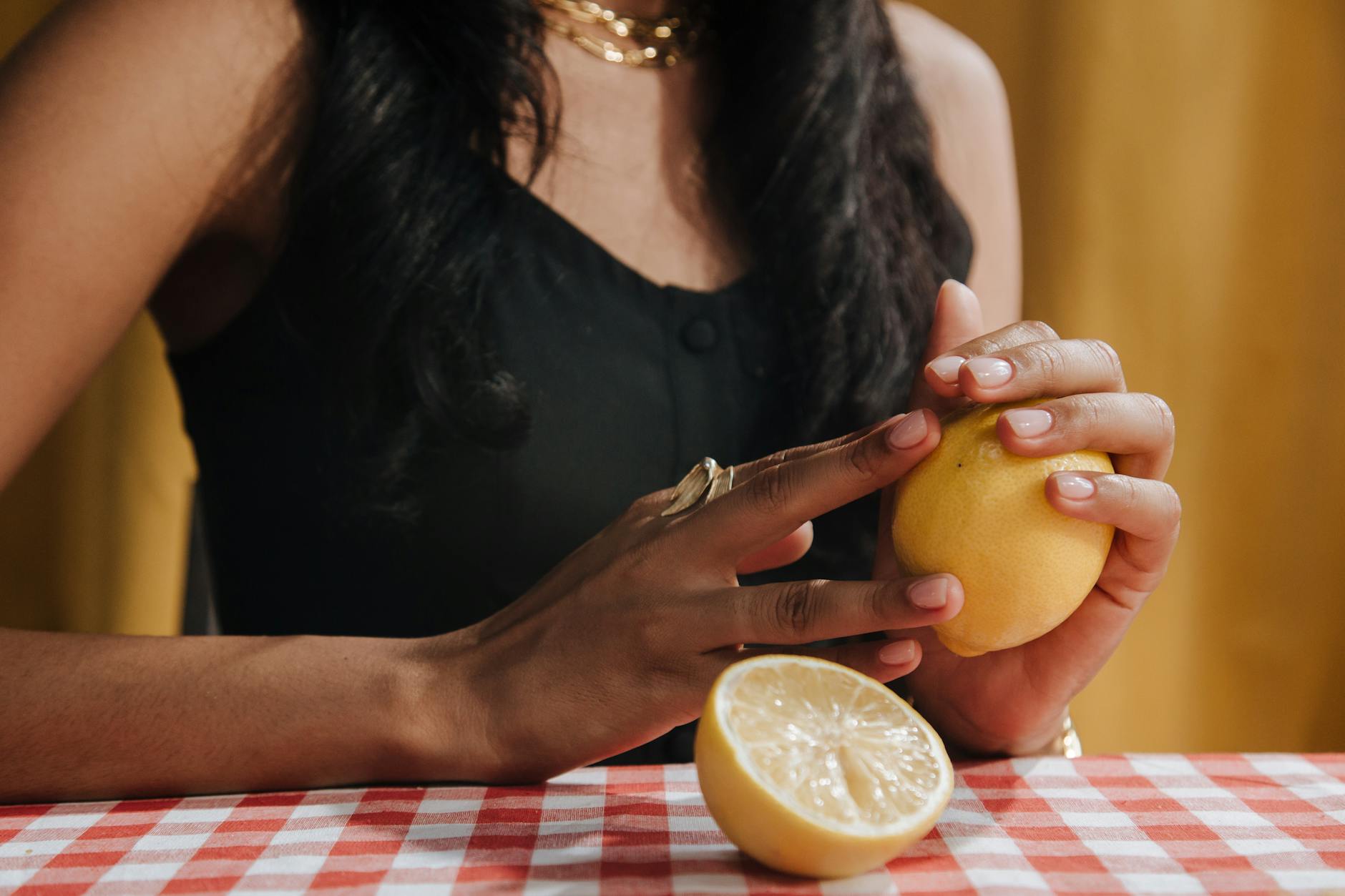 Close-up of hands holding a lemon vibrator against a cozy knitted sweater, symbolizing reconnection with pleasure.
