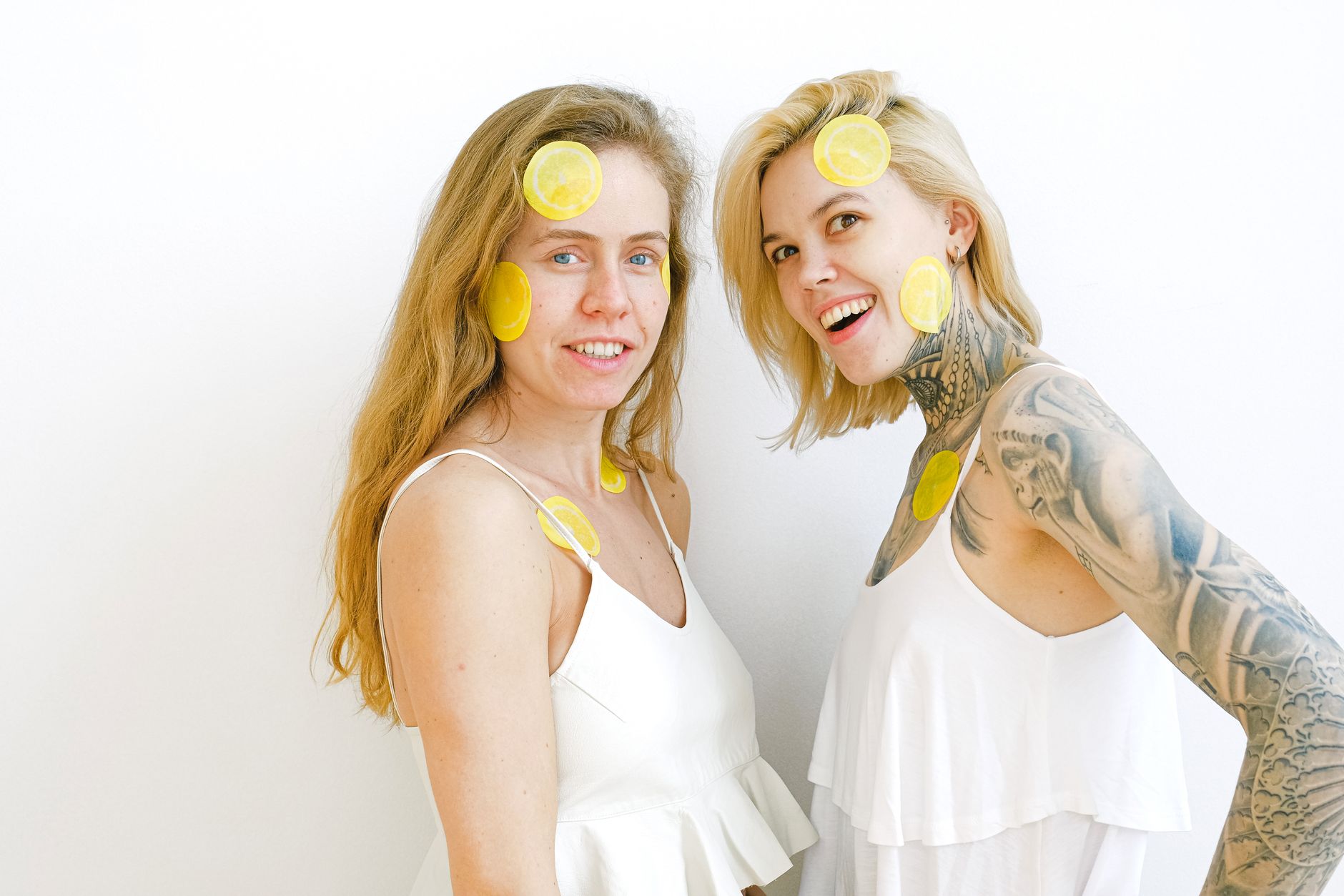A blue clitoral vibrator surrounded by flowers on a bright yellow background