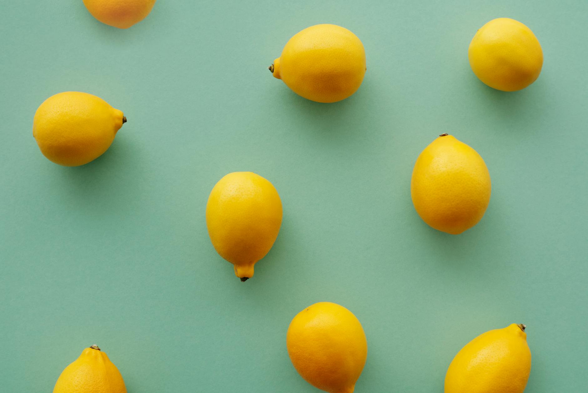 Fresh yellow lemons on a pastel green background, symbolizing natural pleasure and renewal