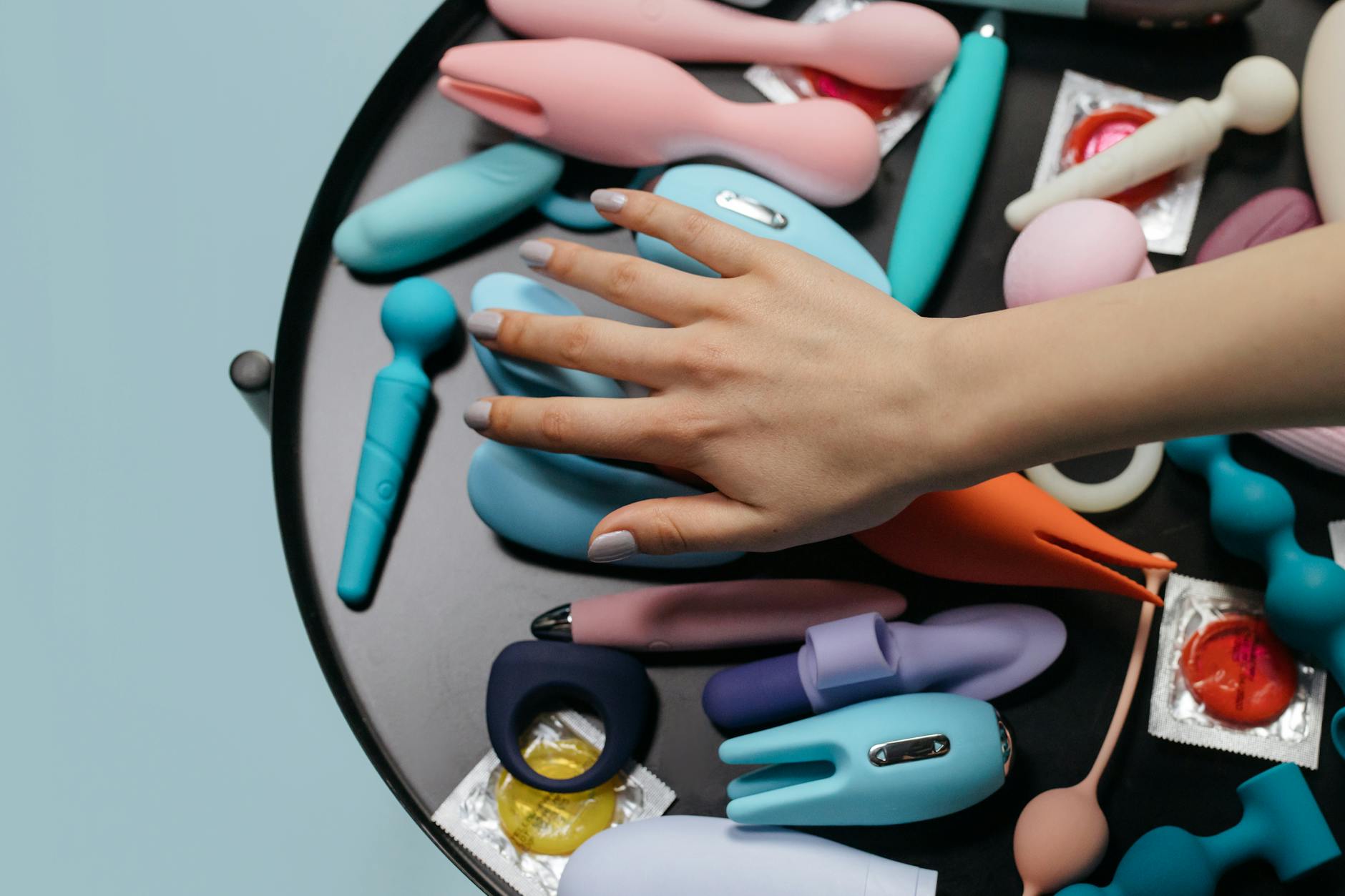 Close-up of hands holding a blue vibrator, representing intimate reconnection after emotional distance