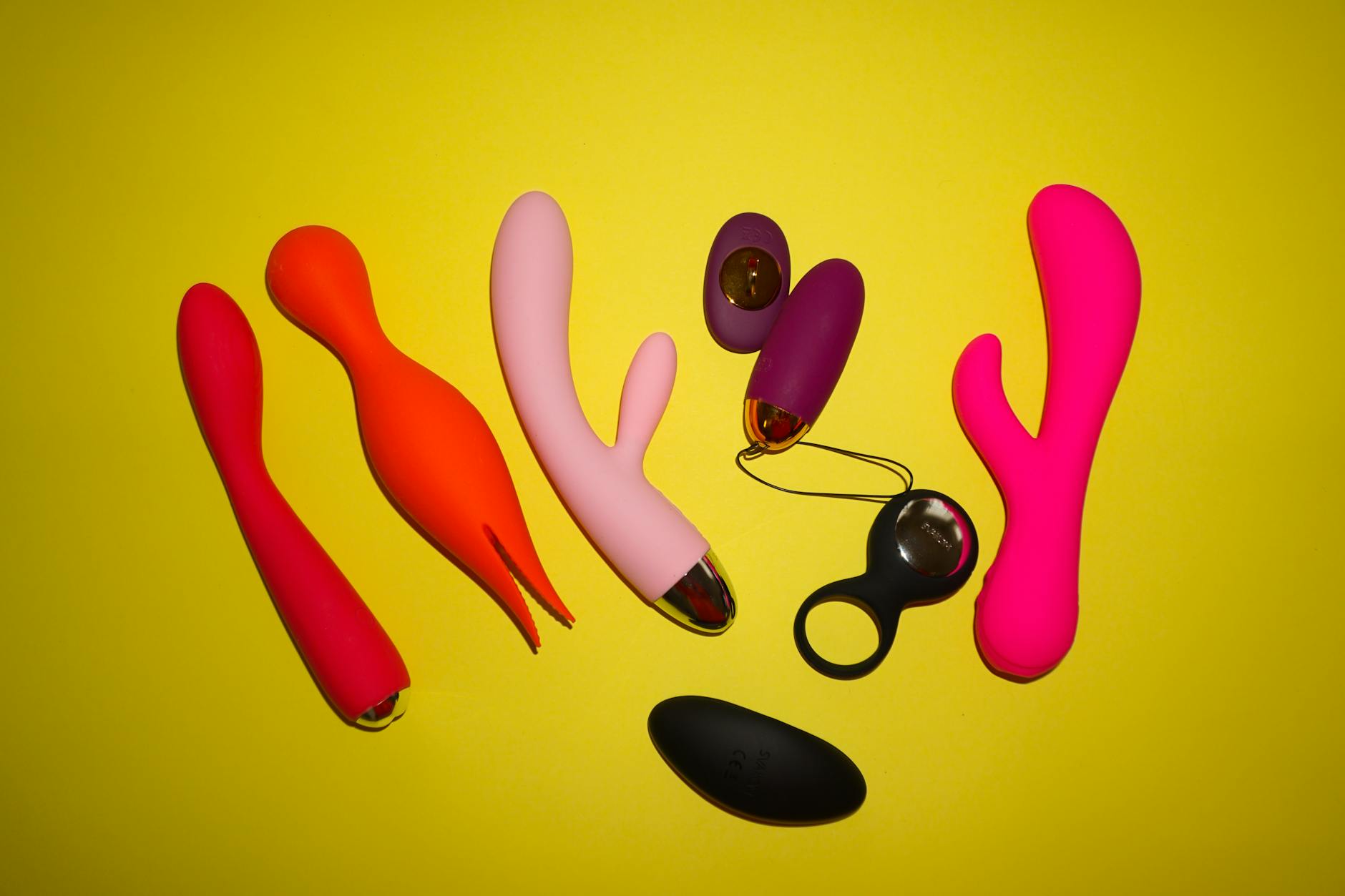 Woman holding silicone vibrators with a thoughtful expression